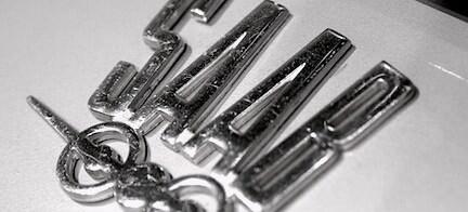 En svartvit bild av en bil med ett logotyp på den. (AI text)