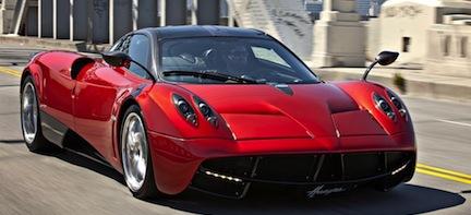 En röd sportbil kör nerför en gata. (AI text)