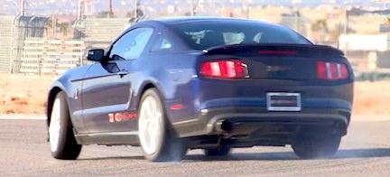 En Ford Mustang GT kör nedför en väg. (AI text)