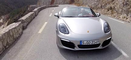 En Porsche Boxster kör nerför en bergsväg. (AI text)