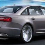 En Audi A6 sedan kör på vägen. (AI text)