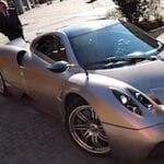 En man och en kvinna står bredvid en sportbil. (AI text)