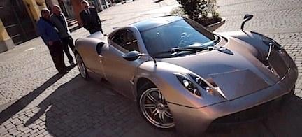 En man och en kvinna står bredvid en sportbil. (AI text)