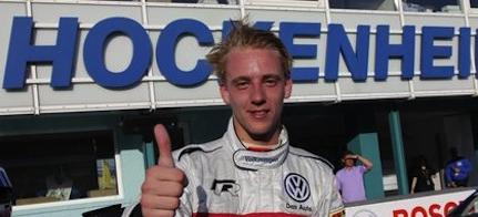 En ung man i en racebil ger en vink med tummen upp. (AI text)