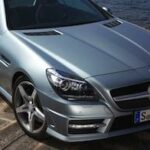 En Mercedes SLK klass parkerad vid en stenig kust. (AI text)