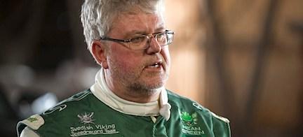 En man i ett grönt jack är på tal med en annan man i ett grönt jack. (AI text)