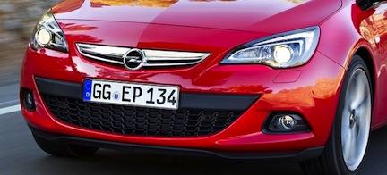 En Opel Astra - en röd bil kör nedför en väg. (AI text)