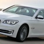 En BMW 7-serie sedan kör på en väg. (AI text)