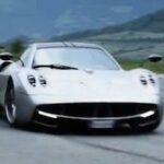 En silverfärgad sportbil kör nerför en bergsväg. (AI text)