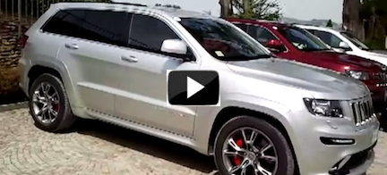 En Jeep Grand Cherokee parkerad framför en garage. (AI text)