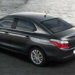 En svart bil står parkerad på gatan nära en sjö. (AI text)