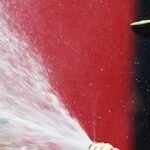 En racerförare sprayer vatten på sin bil. (AI text)