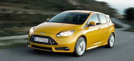 En gul Ford Focus ST kör nerför en väg. (AI text)