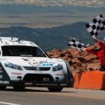 En racebil kör nedför en bergväg. (AI text)