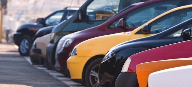En rad bilar parkerade i en parkeringsplats (AI text)