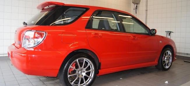 En röd Subaru Impreza GTI parkerad i garagen. (AI text)