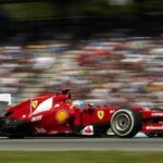 En Ferrari-racebil susar framåt längs banan. (AI text)