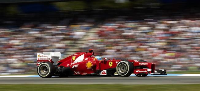 En Ferrari-racebil susar framåt längs banan. (AI text)