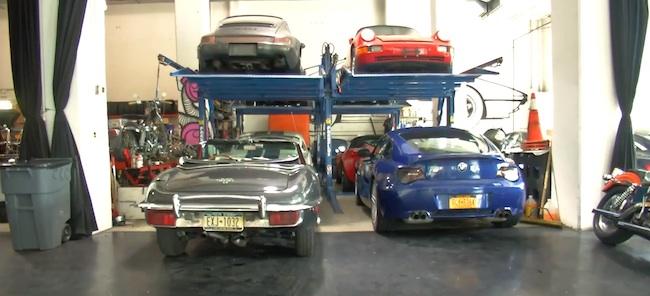 En garage med flera bilar i det. (AI text)