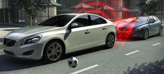 En bil kör nedför gatan med en fotboll i bakgrunden. (AI text)