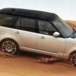 En vit Range Rover kör genom öknen. (AI text)