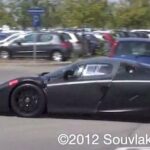 En svart sportbil parkerad i en parkeringsplats. (AI text)