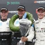 Tre racerförare poserar med sina utmärkelser. (AI text)