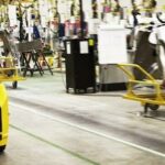 En fabriksarbetare arbetar på en bil. (AI text)