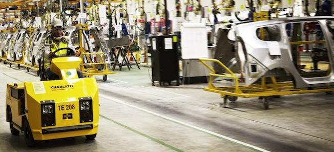 En fabriksarbetare arbetar på en bil. (AI text)