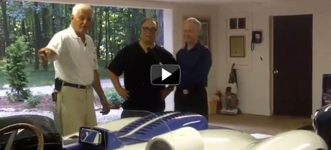 En man och två män står bredvid en racingbil. (AI text)