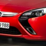 En röd Opel Astra kör på en väg. (AI text)