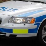 En polisbil parkerad vid en väg. (AI text)