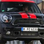 En Mini Countryman kör nedför en gata. (AI text)