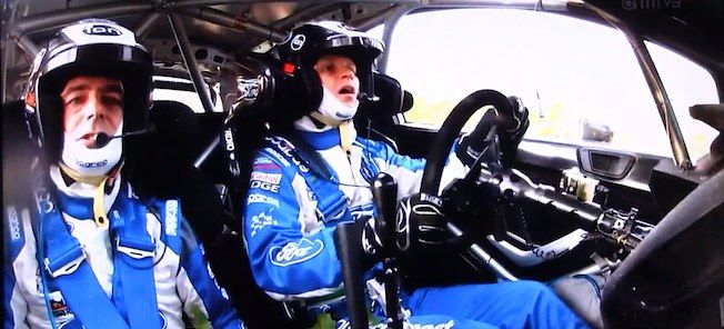 En racerförare och en mekaniker i cockpiten. (AI text)