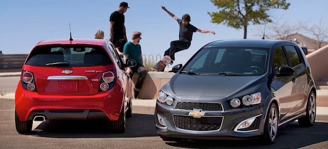 En grupp personer står parkerade framför en bil. (AI text)