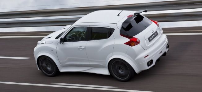 En vit Nissan Juke kör nerför en väg. (AI text)