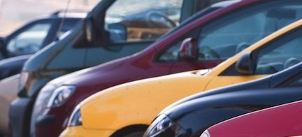 En rad bilar parkerade i en parkeringsplats. (AI text)