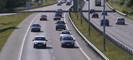 En bil kör nedför en motorväg. (AI text)