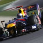 En Red Bull-racingbil accelererar nerför banan. (AI text)