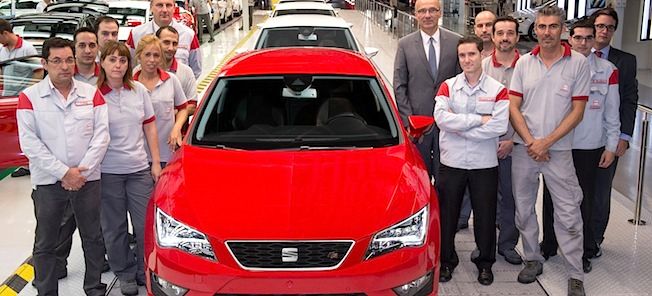 En grupp personer står framför en bil. (AI text)