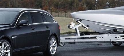 En svart Jaguar XF drajar en båt. (AI text)