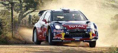 En Citroën C3-rallybil kör nedför en grusväg. (AI text)