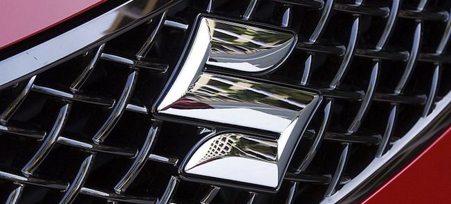 En röd bil med ett grille och logotyp. (AI text)