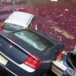 En bil står parkerad i en översvämmad garageplats. (AI text)