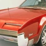 En röd Chevrolet Savana parkerad i en studio. (AI text)