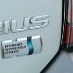 En vit bil med ordet Prius på första framdäcket. (AI text)