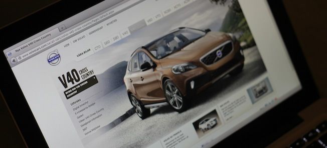 En man tittar på en bilwebbplats på en dator. (AI text)