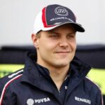 En racerförare i en blå jacka och hatt. (AI text)