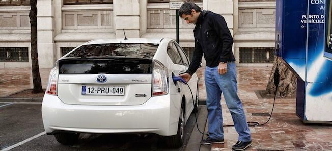 En man laddar sin elbil. (AI text)