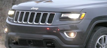Den nya Jeep Grand Cherokee kör nerför en grusväg. (AI text)